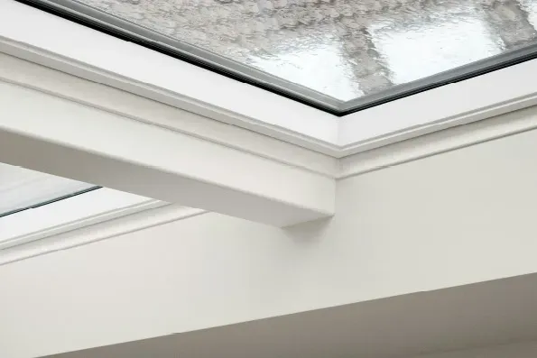Interior view of a modern white framed roof skylight with glass panels